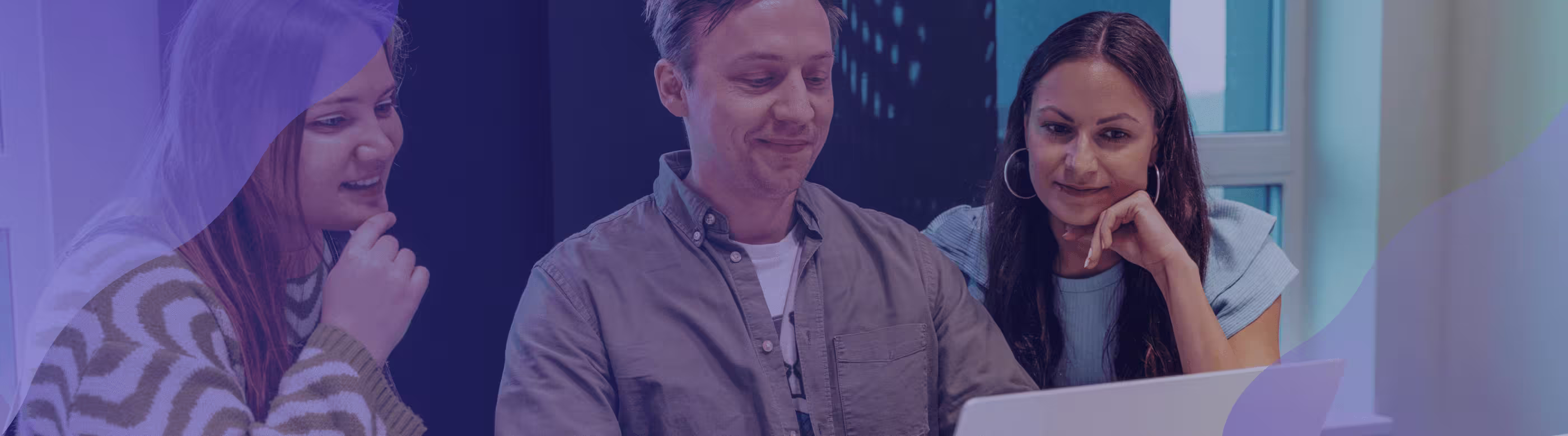 Three people looking at a laptop